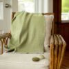 Swans Island Company's Katahdin throw is handwoven in Maine with all natural hand-dyed organic merino wool, Shown here in Thyme.