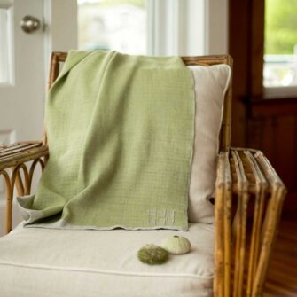 Swans Island Company's Katahdin throw is handwoven in Maine with all natural hand-dyed organic merino wool, Shown here in Thyme.