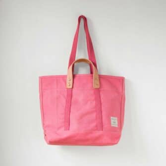 Swans Island Company's Small East West Canvas Tote by Immodest Cotton. Sturdy canvas tote with detachable leather handles. Shown here in Flamingo color.
