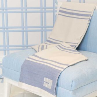 Casa Branca x Swans Island - Branca Grande Throw . 100% soft merino wool with hand-dyed stripes and ivory silk binding. Handwoven in Maine. Shown here in Sky Blue.