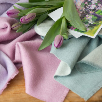 Swans Island Company's Reversible Suri Alpaca Scarf in Soft Pink / Light Purple detail with tulips.