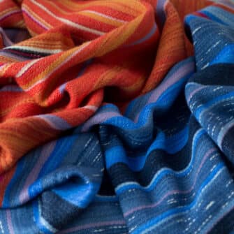 Swans Island Company's Horizon Limited Edition 2026 Throw - A tangible homage to the vibrant colors of first light and golden hour when the sun rises and sets. Handwoven in Maine with hand-dyed wools - a textiles collectors piece. A closeup detail of the transition from water to sky.