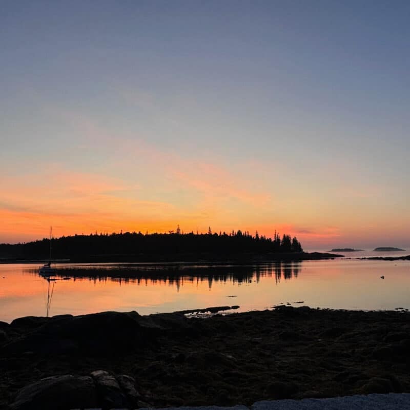 Swans Island Company's Horizon Limited Edition 2026 Throw was inspired by the vibrant colors of sunrise and sunset. A Blue and Orange Maine coast sunrise with islands silhouetted in the distance.