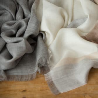 Swans Island Company's Gossamer Alpaca Wrap is whisper thin baby alpaca in undyed natural colors. White with beige, light grey with beige and beige with white.